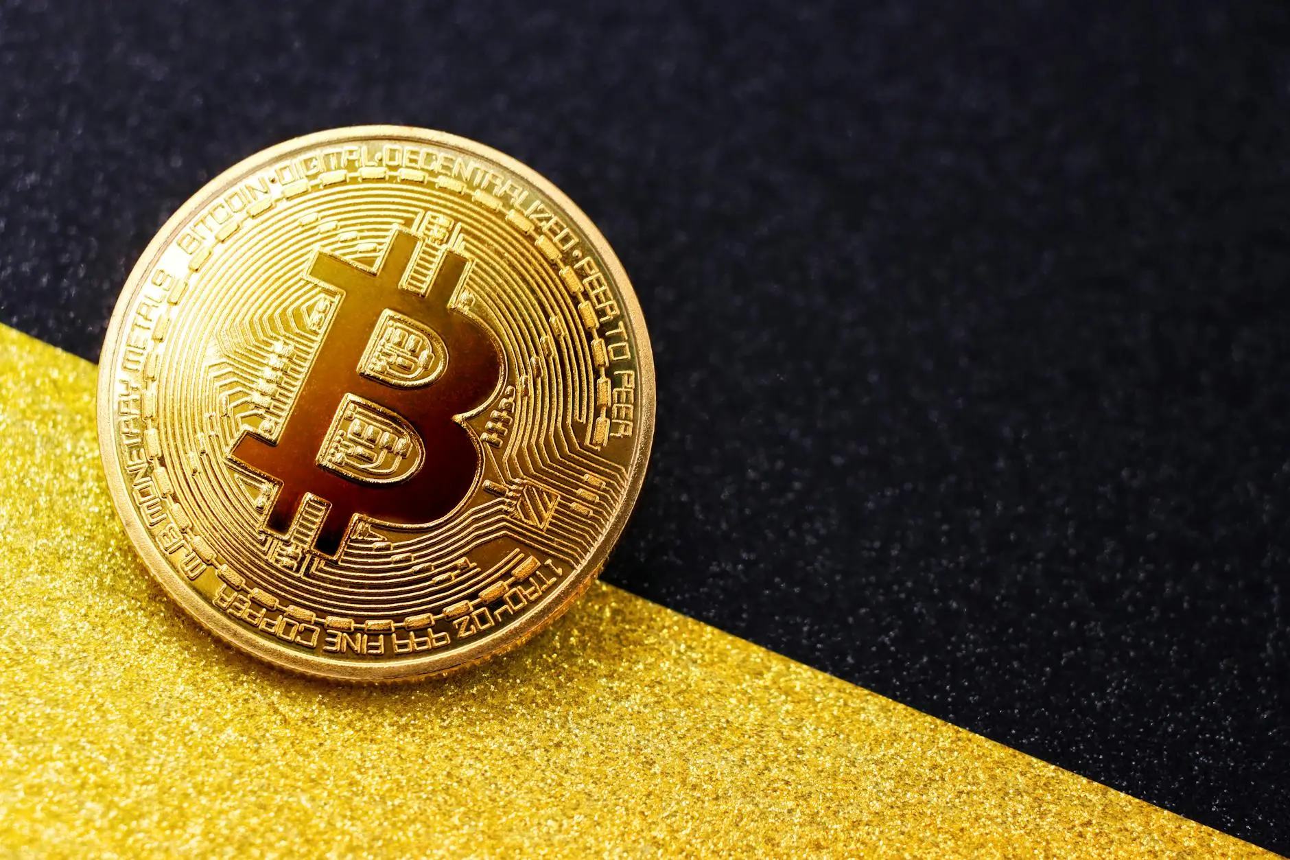 Golden Bitcoin coin on a black and gold glitter background.