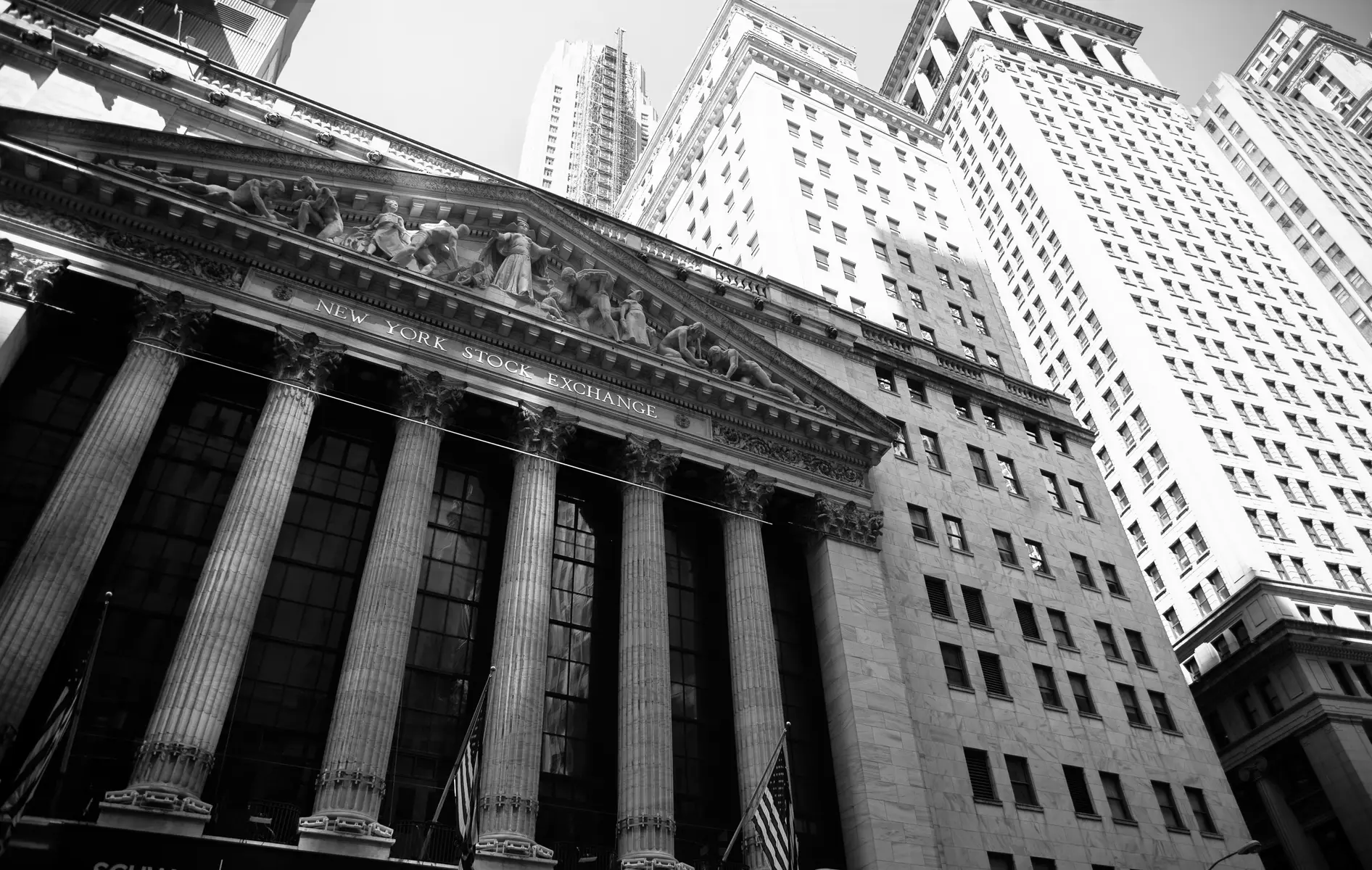 Vista em preto e branco da fachada neoclássica do edifício da Bolsa de Valores de Nova York.